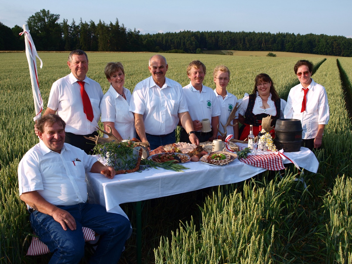 Die Familie am gedeckten Tisch im Getreidefeld
